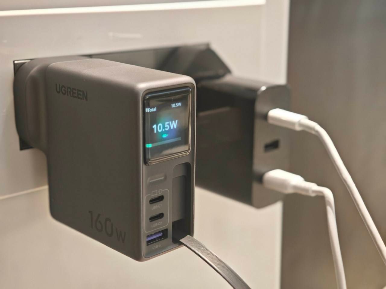 UGREEN Nexode Pro charger display showing 10.5W total output while plugged into a wall